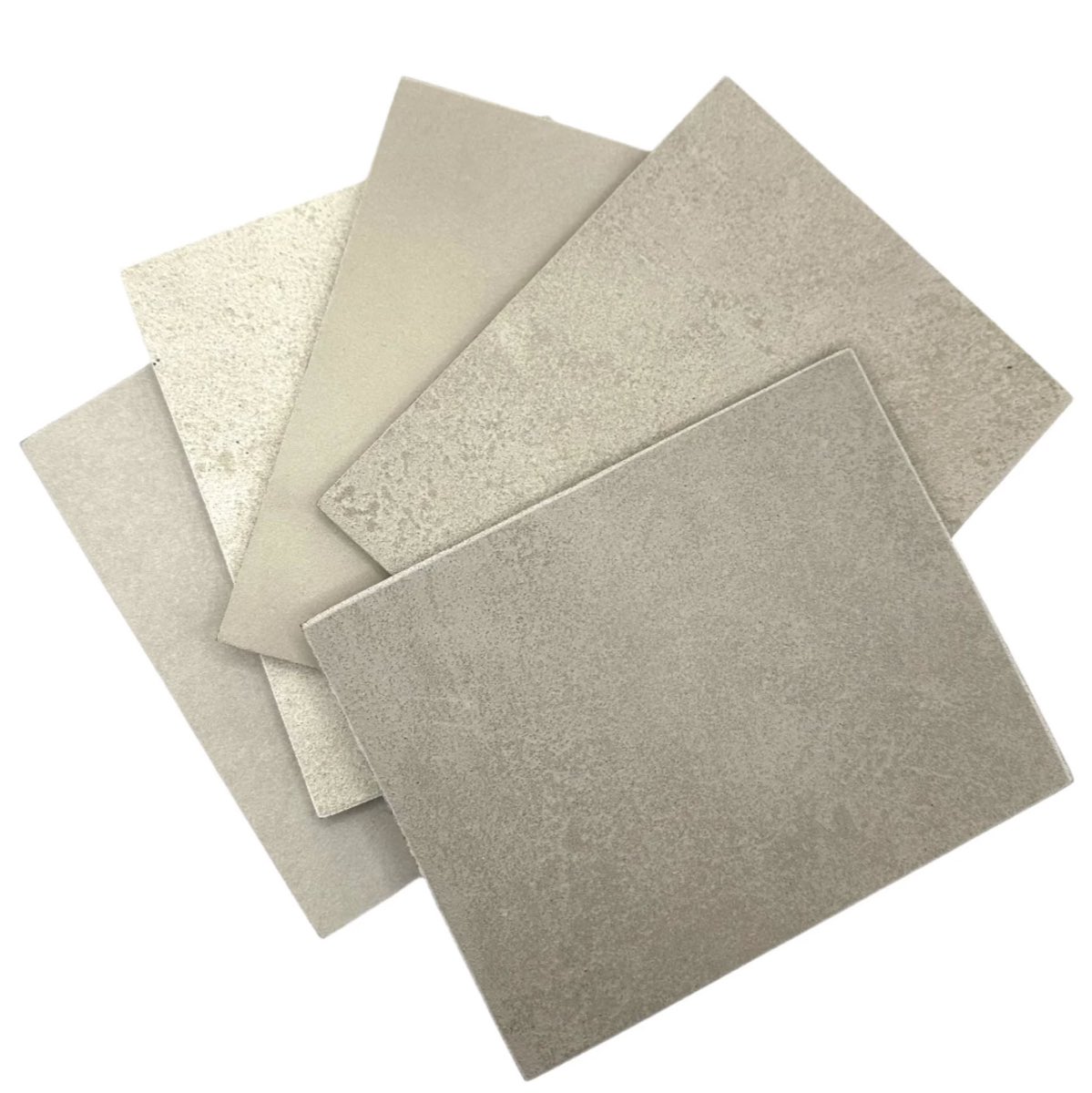 Échantillons de plaques d'enduit et de microbéton, gris et beiges, aux textures différentes