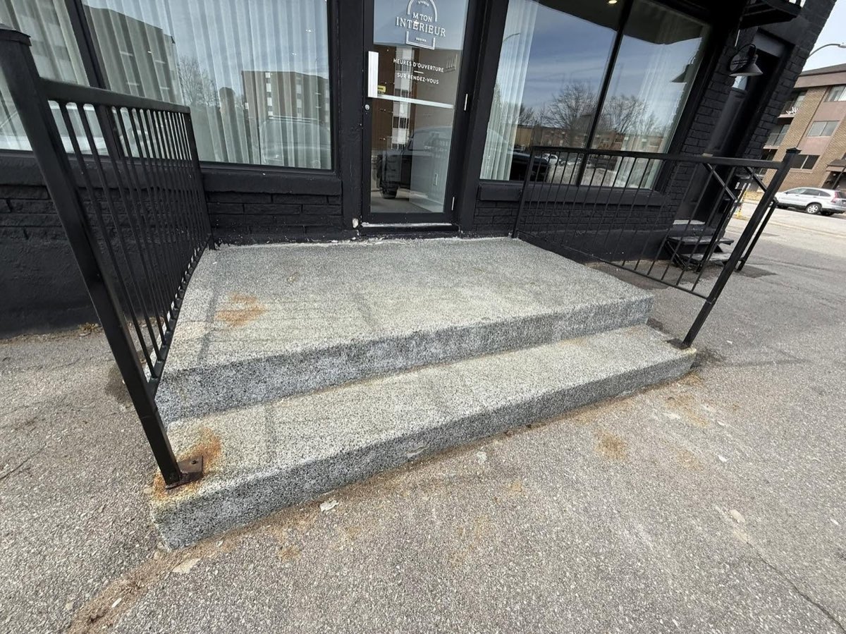 Avant les travaux, escalier d'entrée commerciale en béton exposé, surface grise et grenue