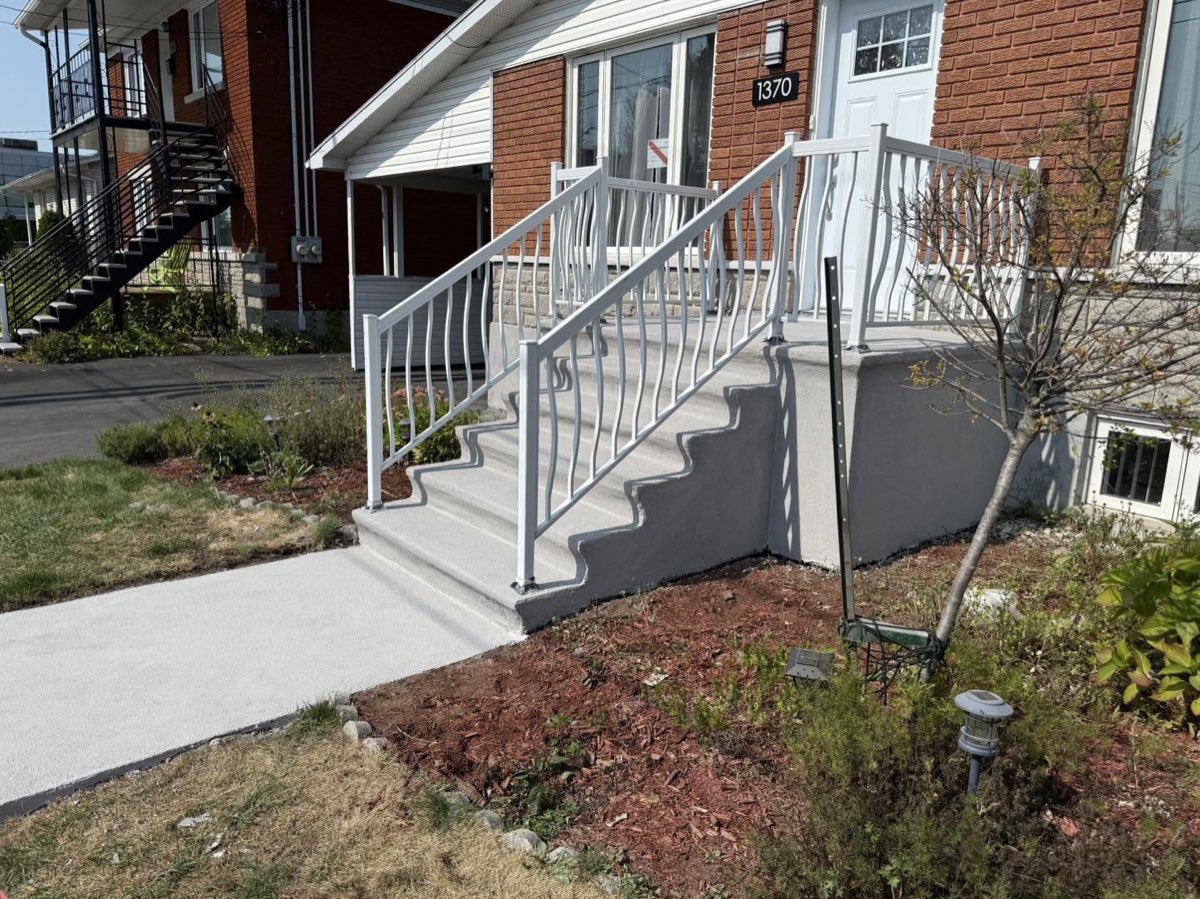Après les travaux, le même escalier avec un muret refait et une surface lisse et régulière