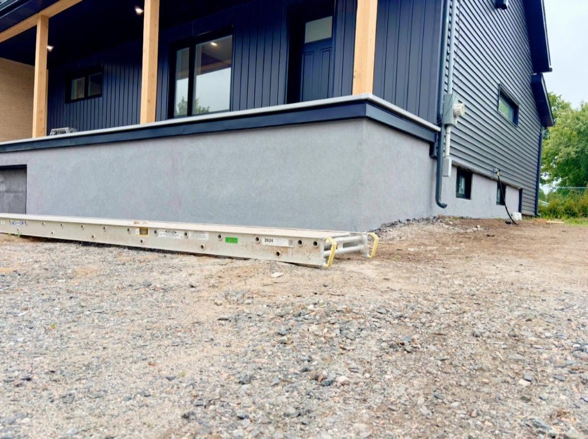 Après les travaux, le même solage fini en gris uniforme sur tout le pourtour